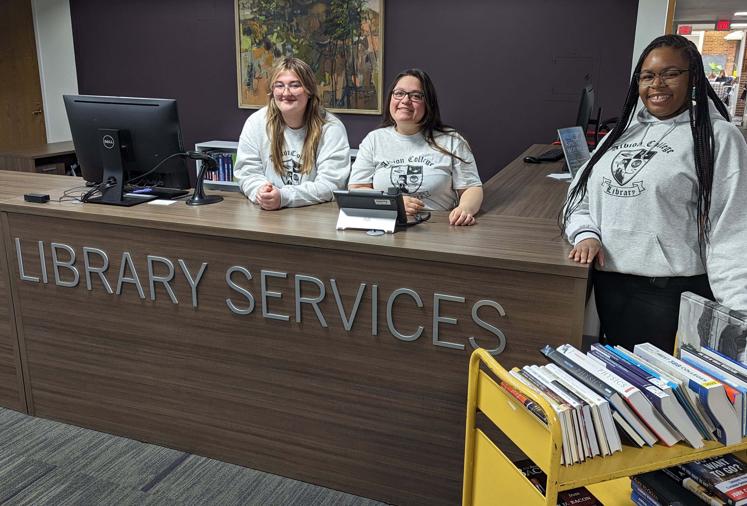 Students working at the Library Services Desk on the main floor of Mudd.
